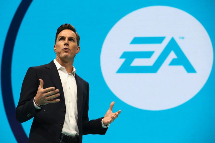 A man taking a picture of the EA logo.