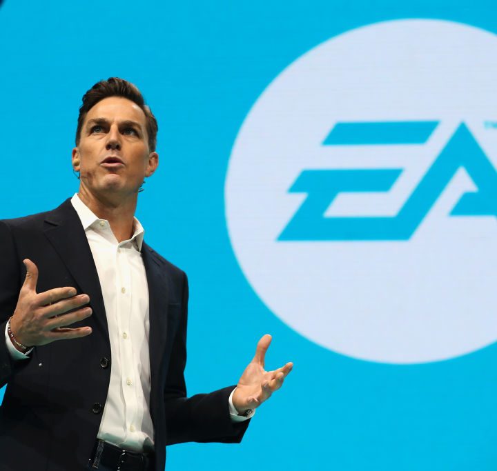 A man taking a picture of the EA logo.