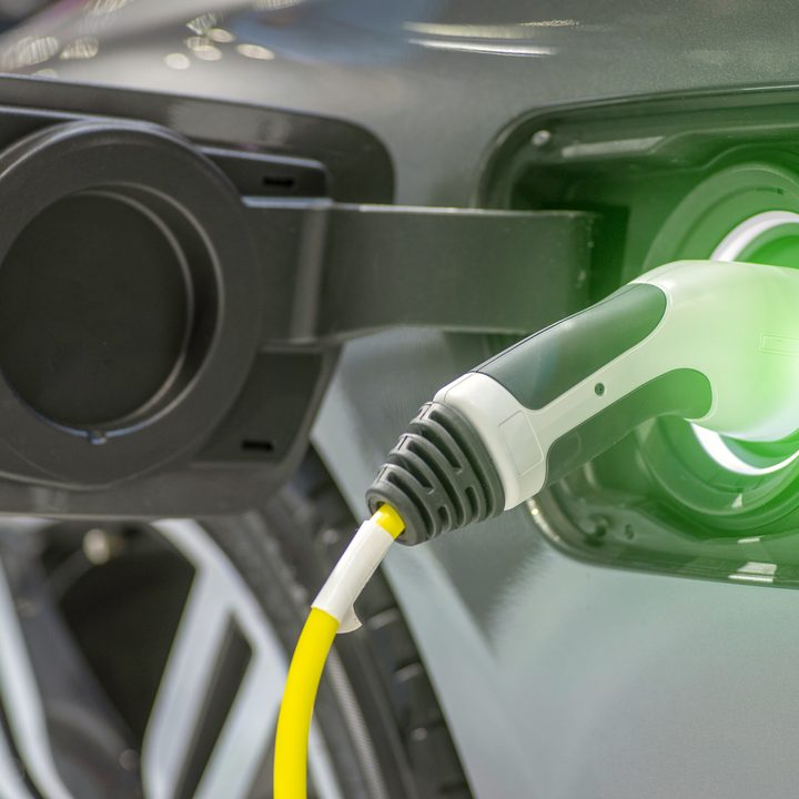Close up of the Hybrid car electric charger station with power supply plugged into an electric car being charged.