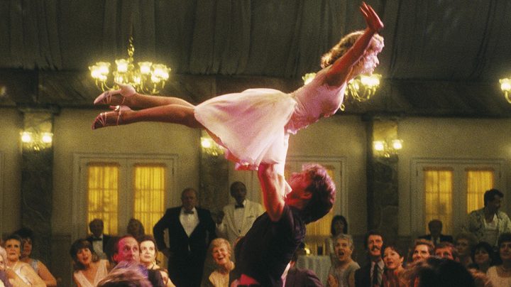 A male fance hoists a woman in the air.