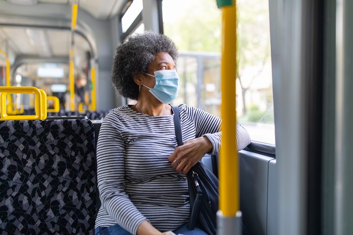 Woman wearing face mask while using public transit.