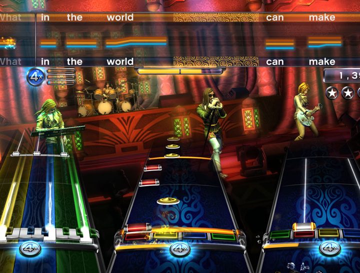 A keyboard, drums, guitar, and vocalist playing on stage.