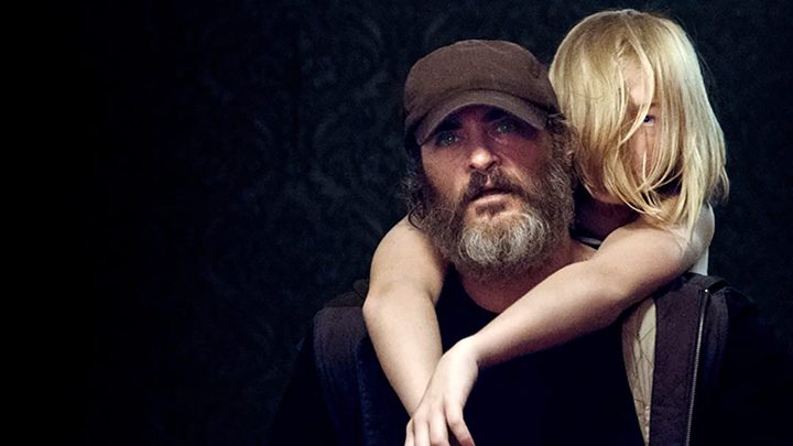 A girl hangs off a man in You Were Never Really Here.