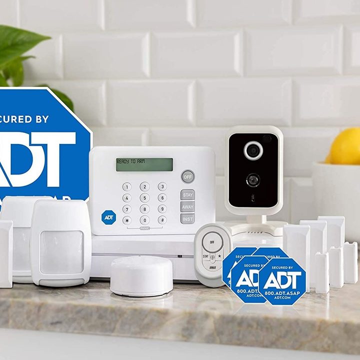 ADT security devices and signs sitting on a counter.