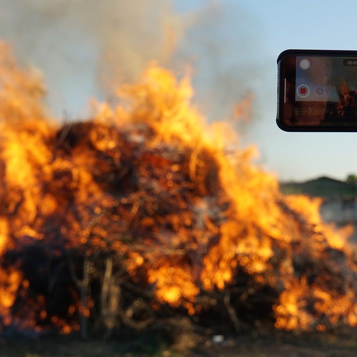 An iphone filming a bonfire.