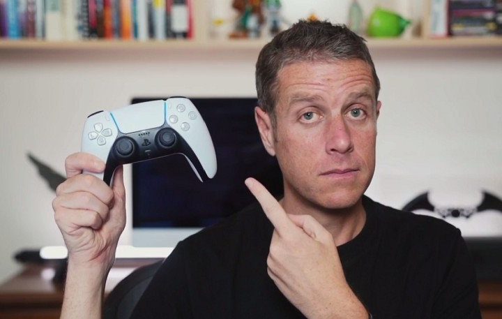 Geoff Keighley holding a dualsense controller.