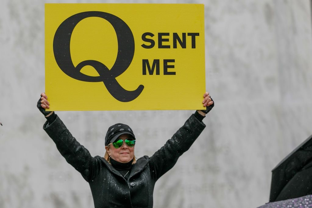 QAnon conspiracy theorist holds a sign