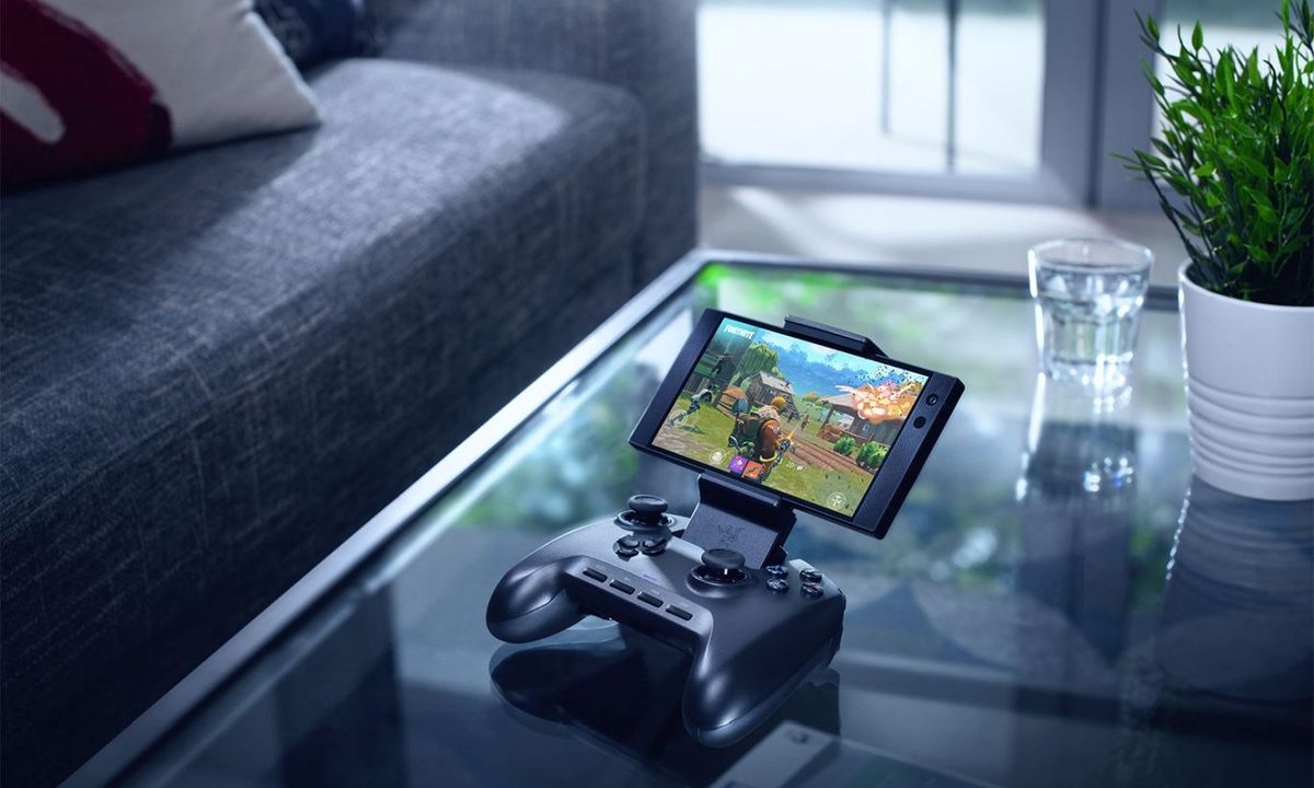 Razer Raiju Mobile Games Controller with a smartphone attached, on a table in a sitting room