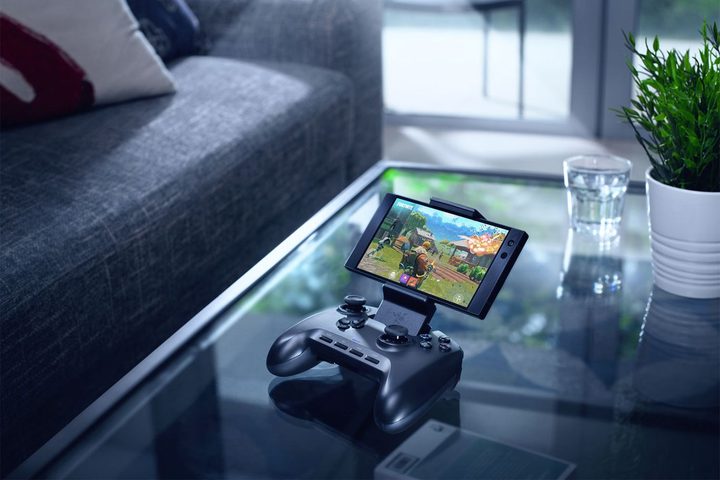 Razer Raiju Mobile Games Controller with a smartphone attached, on a table in a sitting room