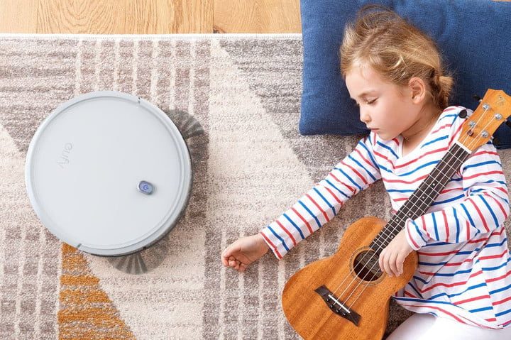Eufy 11s robovac on a carpet near a sleeping child.