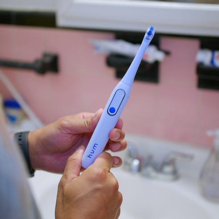 Hum by Colgate Smart Toothbrush in hand