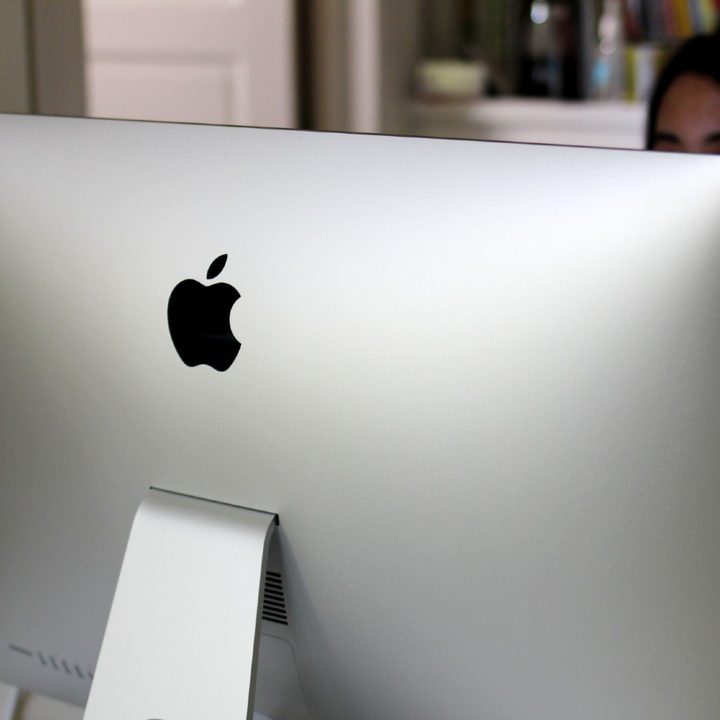 The back of a silver iMac in an office.