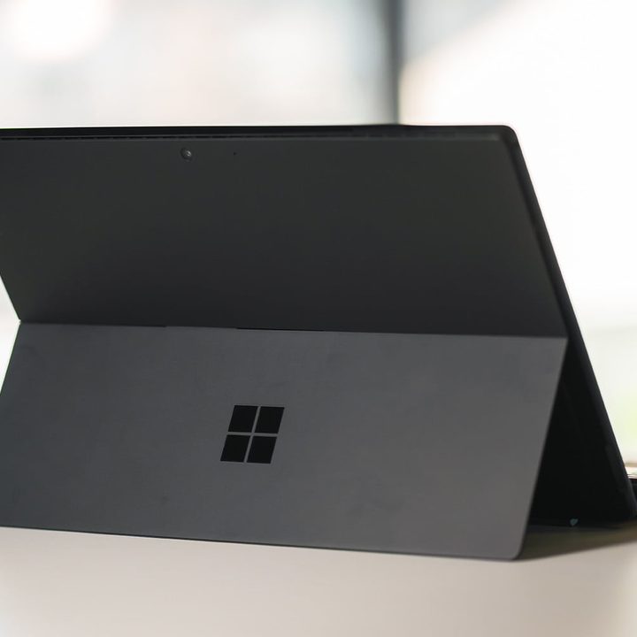 The rear of the Microsoft Surface Pro 6 on a desk next to a plant.