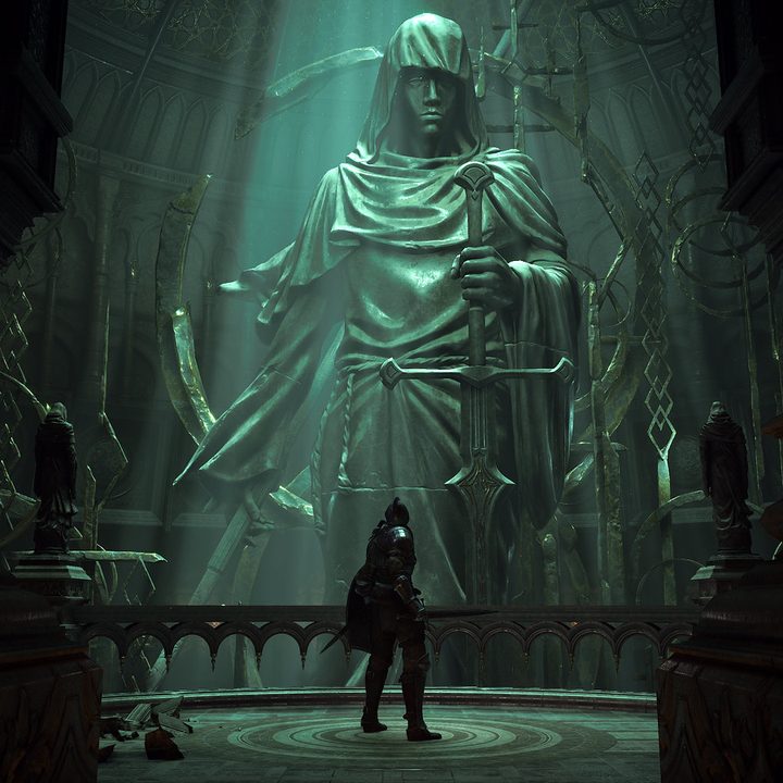 The hero of Demon's Souls stands in front of a stone statue.