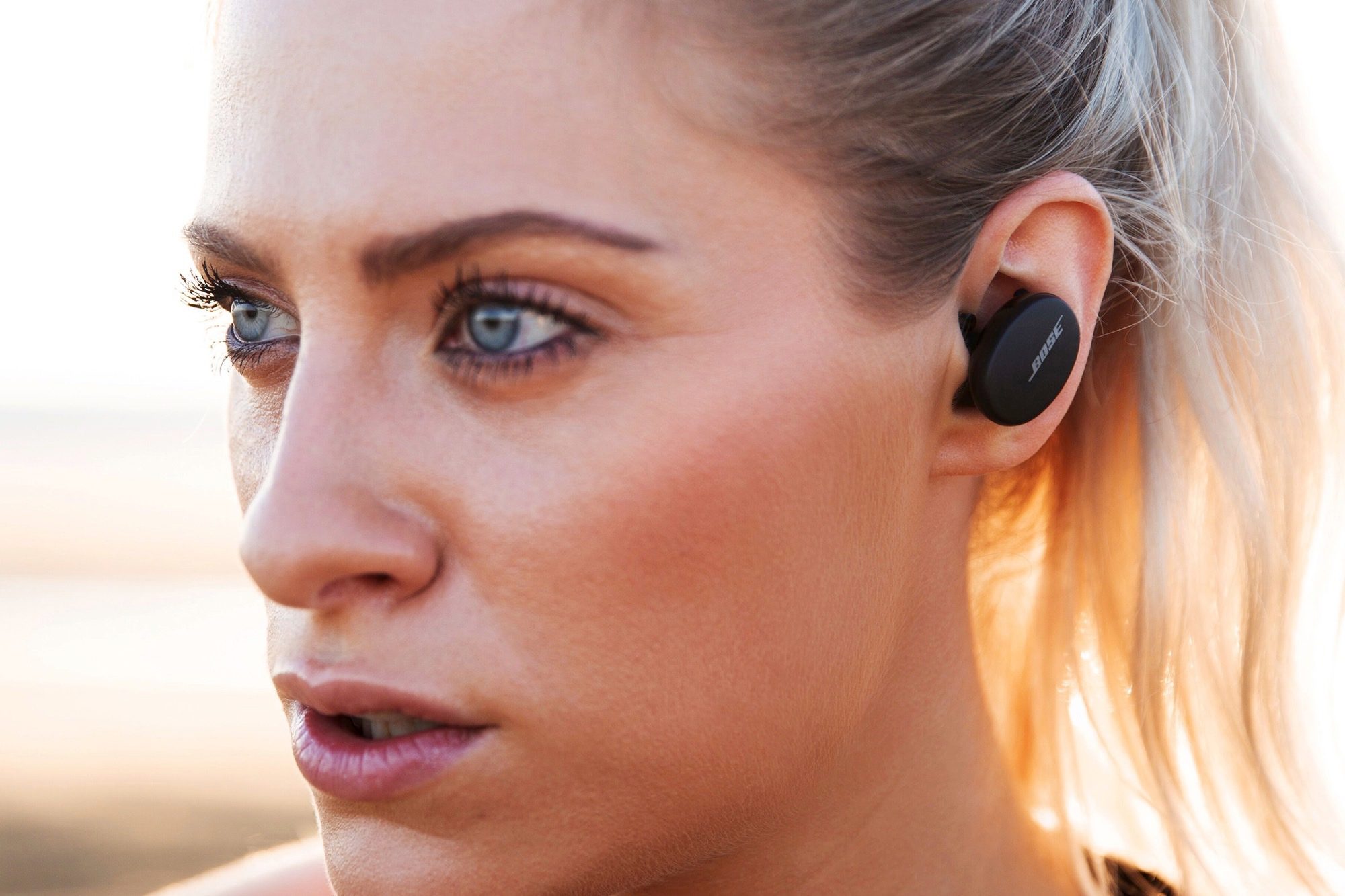 Woman wearing Bose Sport Earbuds.