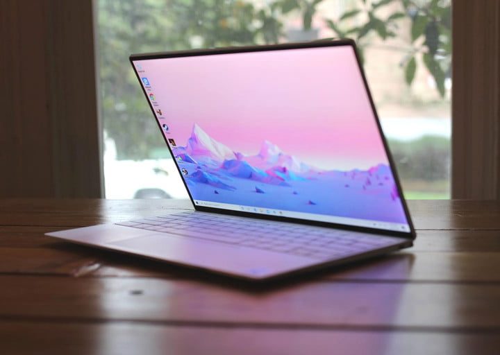 The Dell XPS 13 open on a table in front of a window.