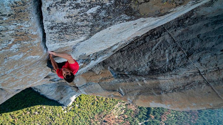 A rock climber makes his ascent on a wall.