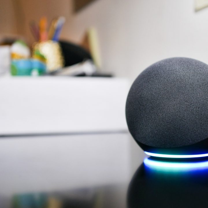 Amazon Echo (4th Gen) glowing LED light ring on top of table.