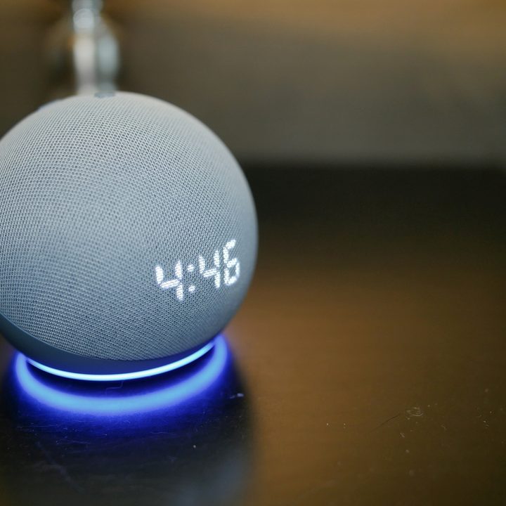 Amazon Echo Dot (4th Gen) with Clock LED light on table.