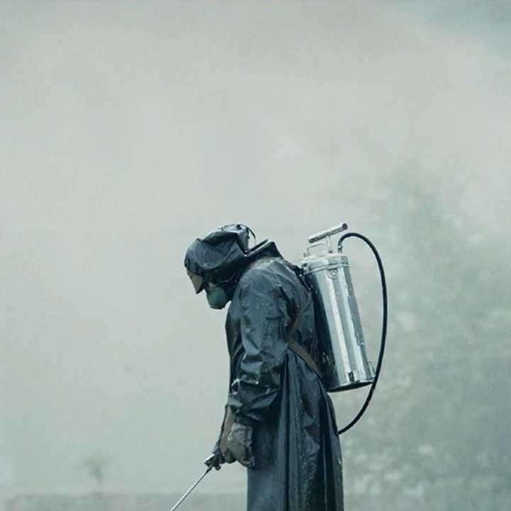 A man in a hazmat suit sprays wter.