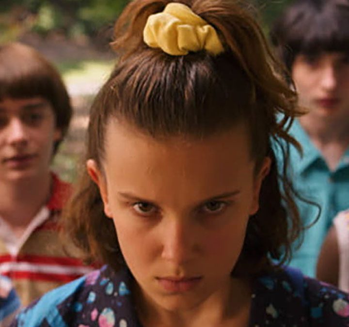 Eleven looking angry as she tries to control something with her mind on Stranger Things.