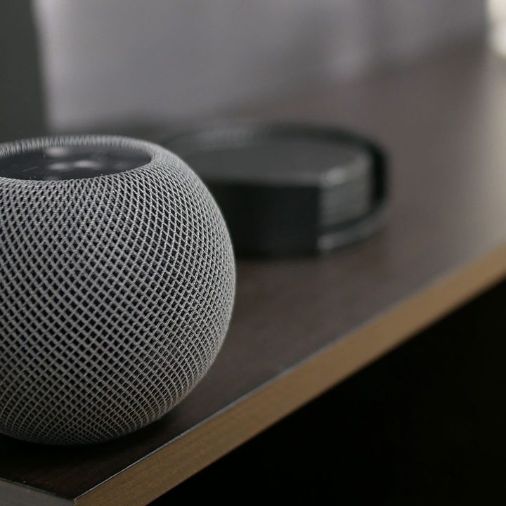 Apple HomePod Mini sitting on top of a shelf.