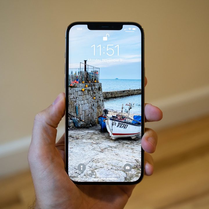 A hand holding the iPhone 12 Pro Max.