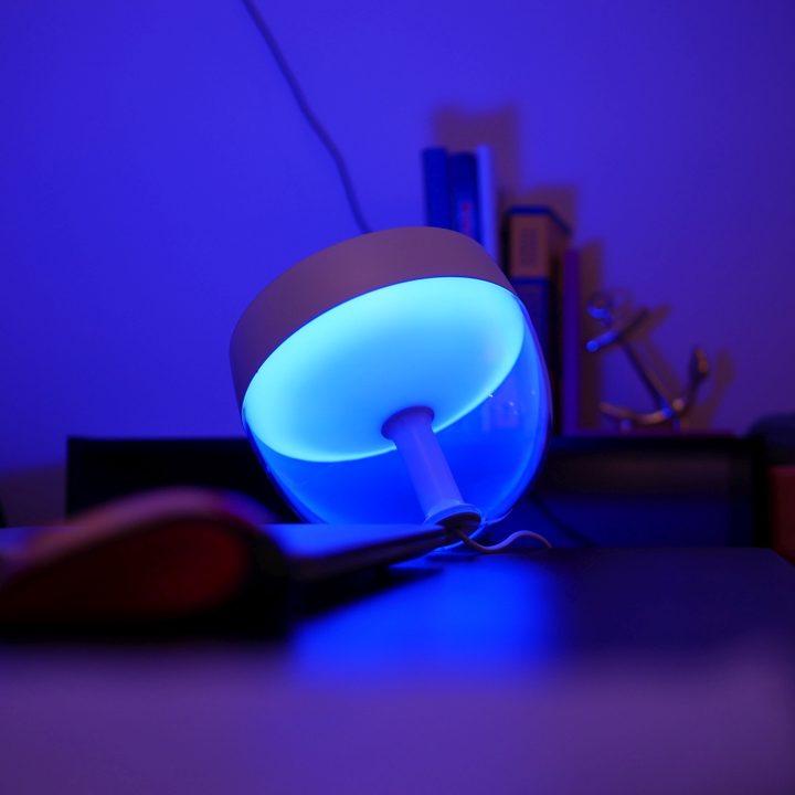 The Philips Hue Iris table lamp glowing blue.