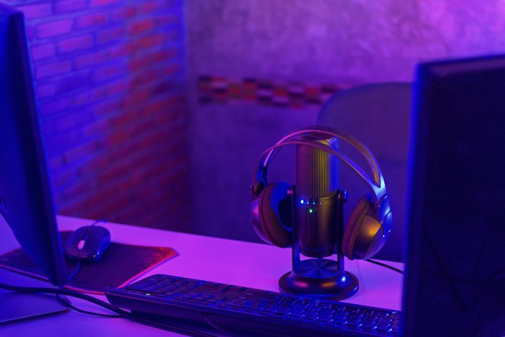 A podcast microphone with headphones on top.