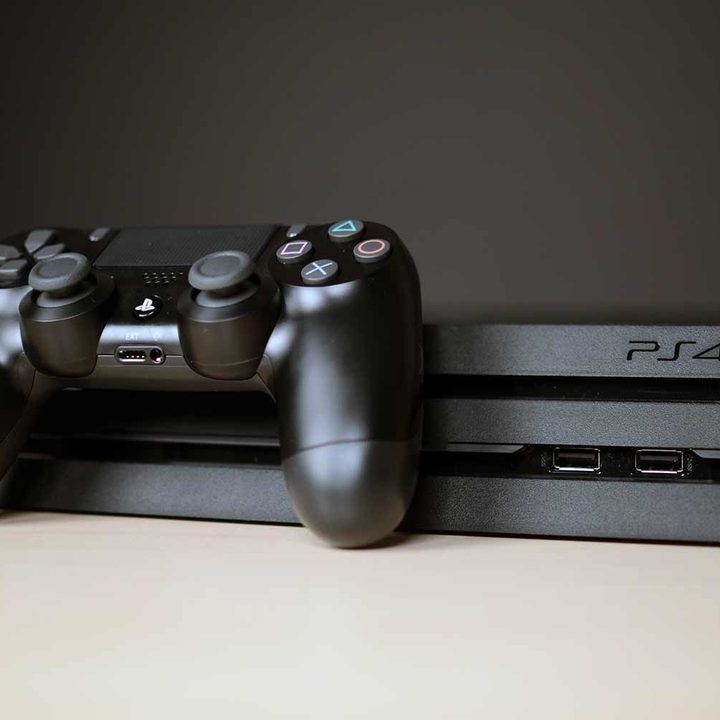 PlayStation 4 console with a controller sitting on top.