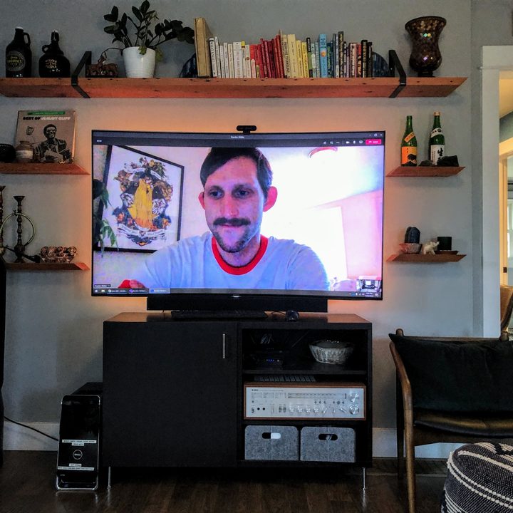 Video call in progress displayed on a television screen in a person's living room.