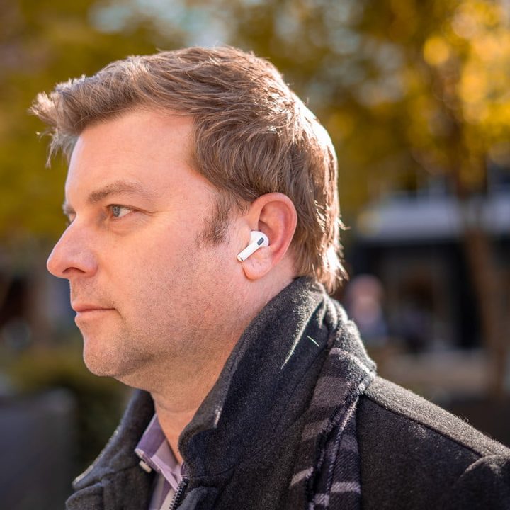 Man wearing Apple AirPods Pro outdoors.