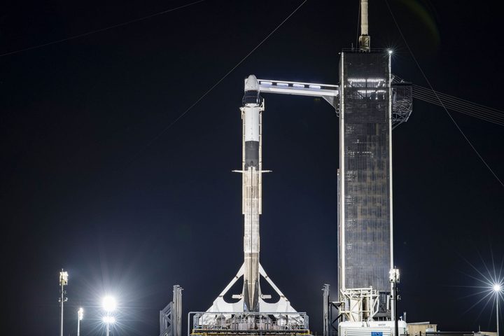 A SpaceX Falcon 9 rocket, with the upgraded Cargo Dragon spacecraft atop, stands ready for liftoff