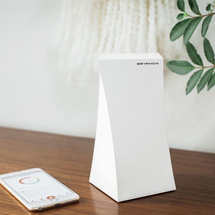 Tabletop image of a Gryphon router with smartphone app nearby.
