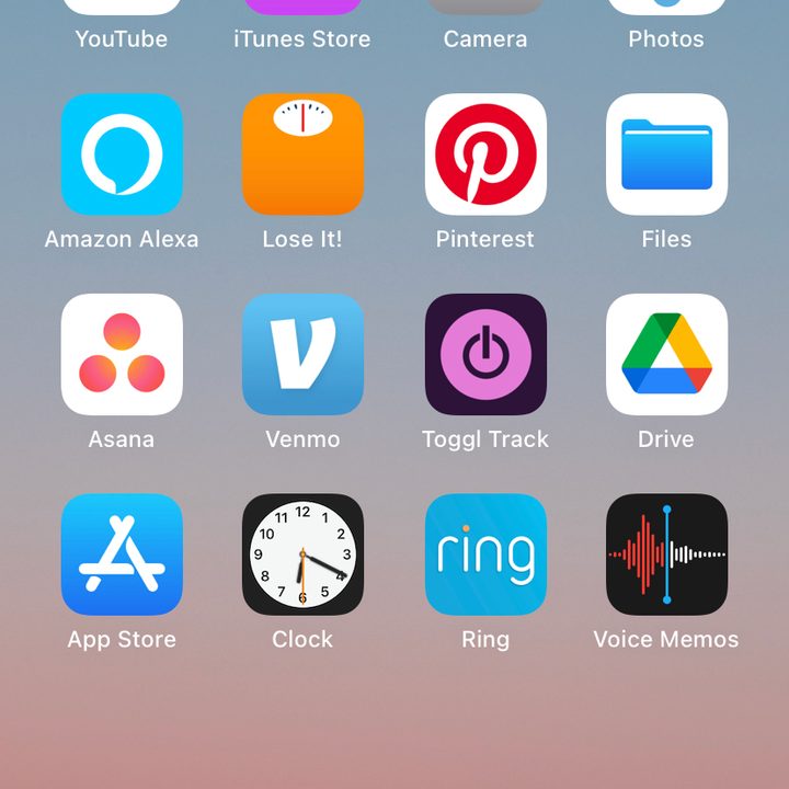 iPhone home screen with app icons on wallpaper of the sky over mountains.