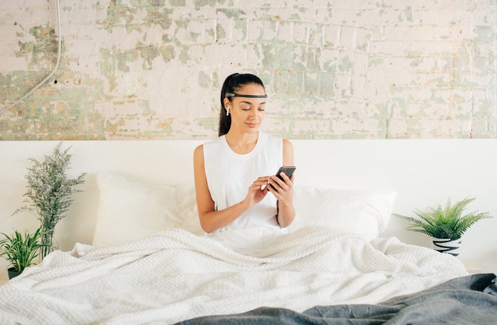 Young woman wearing the Muse 2 headband in bed