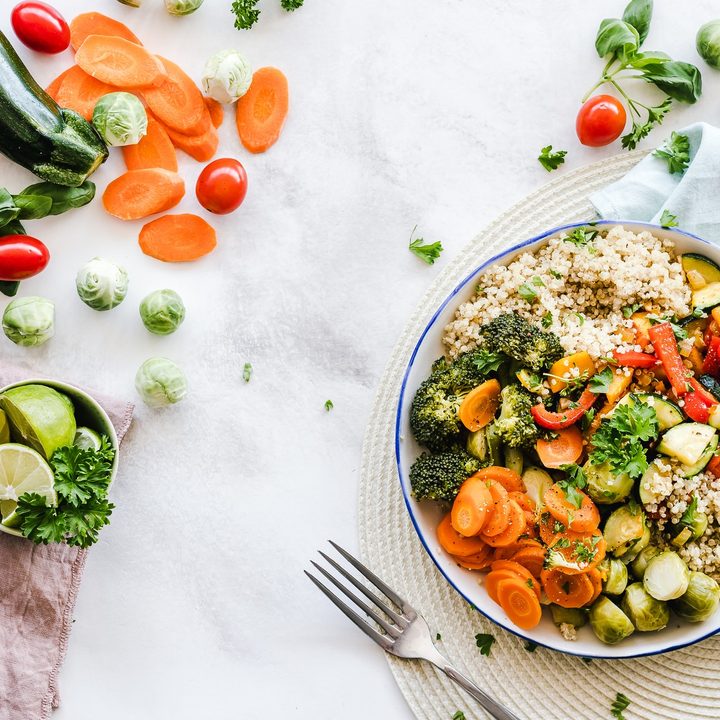 Stock image showing a colorful salad on a plate surrounded by other vegetables and food.