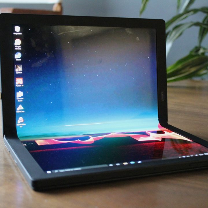 The ThinkPad X1 Fold sits on a table, bent into laptop mode.