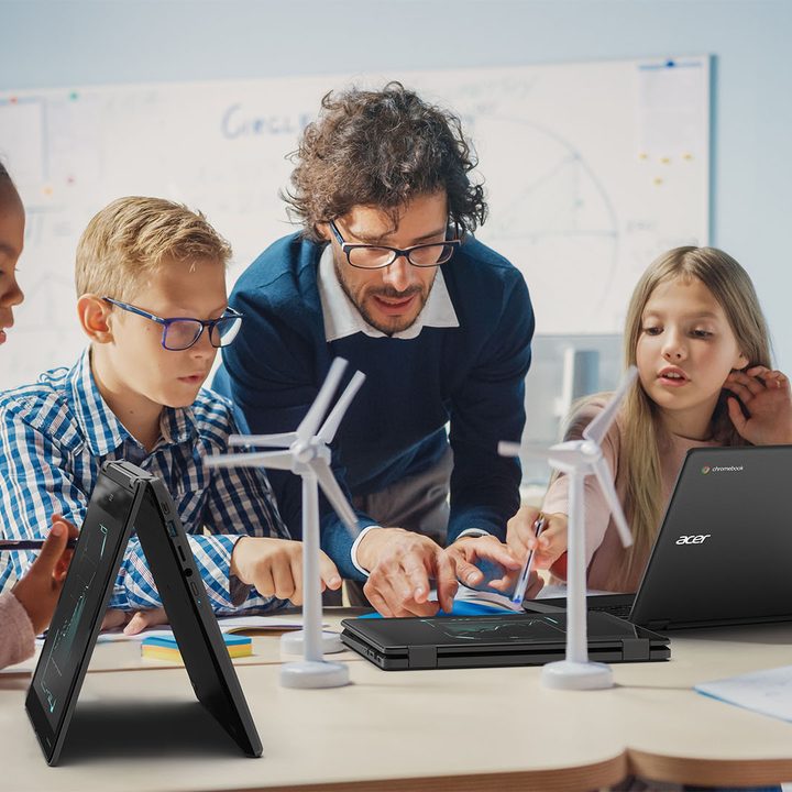 Students with a teacher in front of chromebooks.