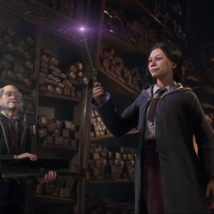A student holding a wand in Hogwarts Legacy.