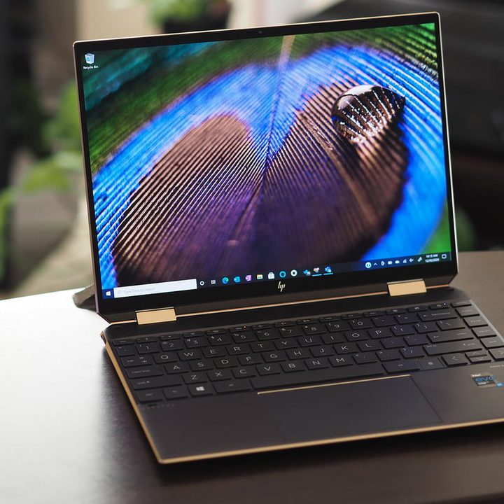 HP Spectre x360 14 front view with a close-up image of a peacock feather on the laptop's display.