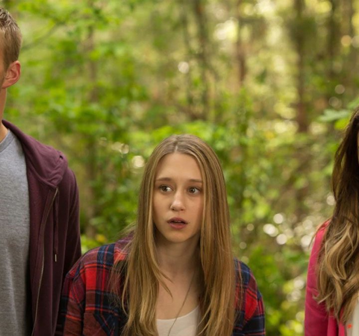 Three characters from The Final Girls standing in the woods.