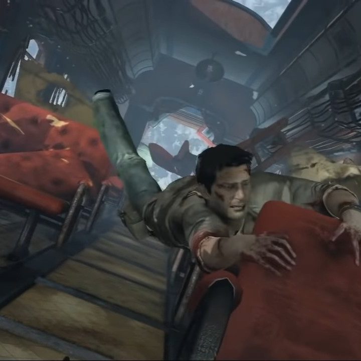 Nathan Drake hangs off a train seat in Uncharted 2.
