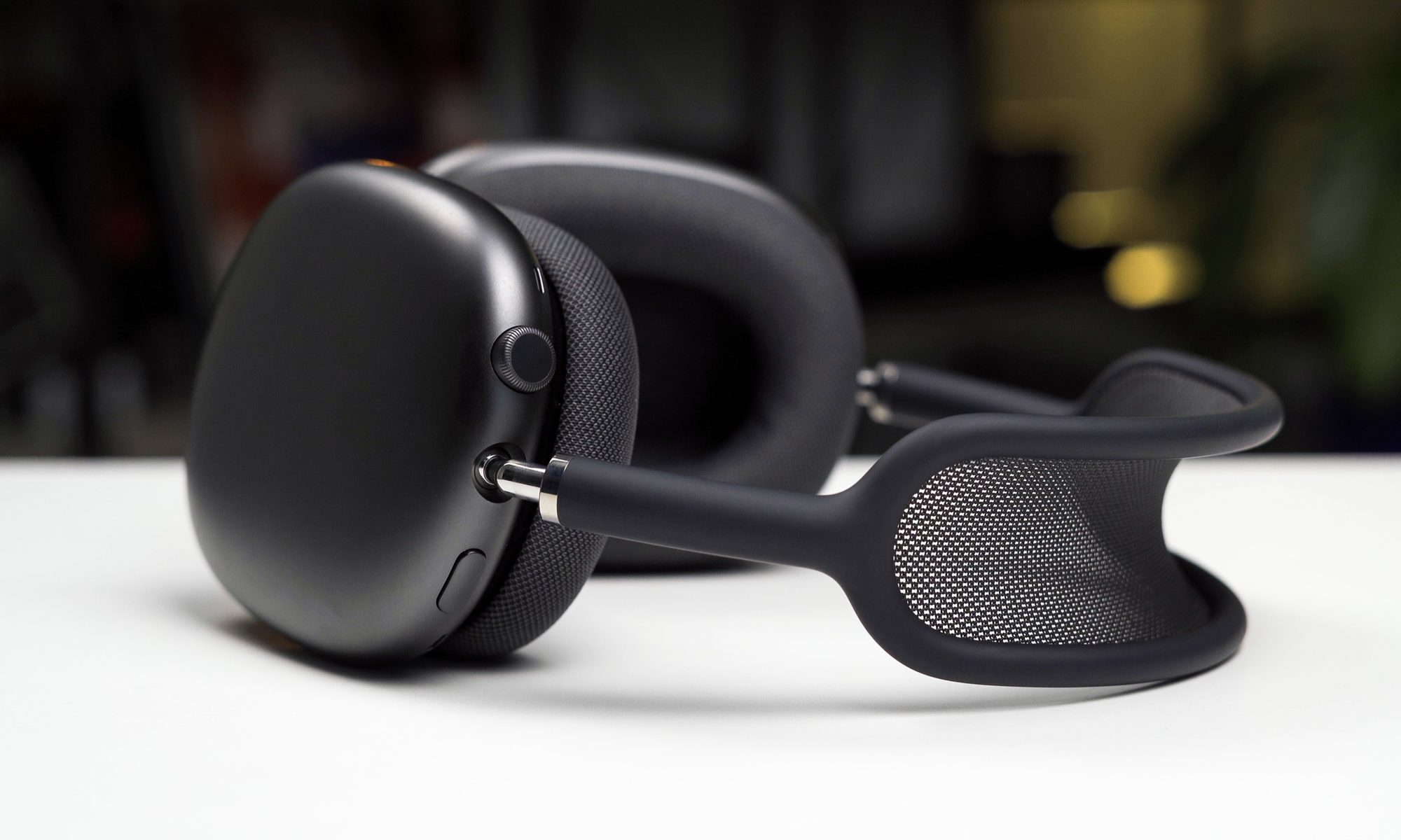 The Apple AirPods Max on a surface, viewed from the side.
