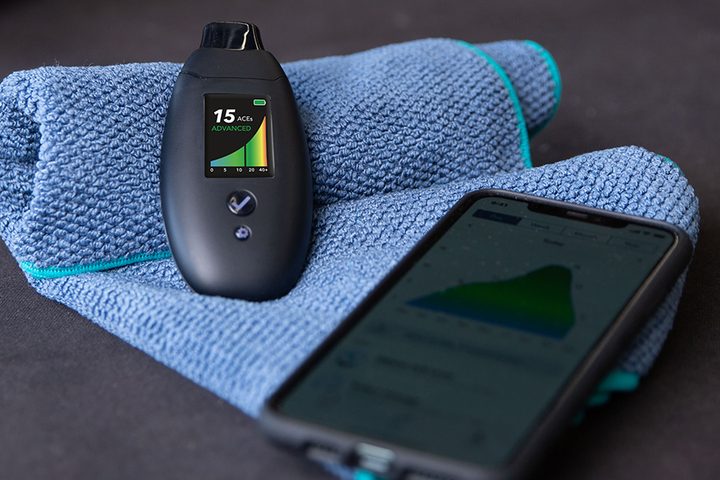 Biosense breath ketone detector resting on a towel beside a smartphone