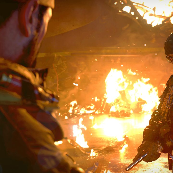 A soldier loading a pistol in a burning building.