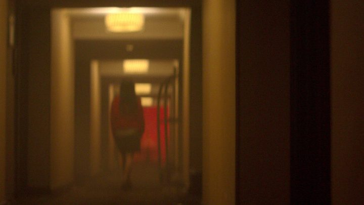 A woman walks down a hallway in Crime Scene: The Vanishing at Cecil Hotel