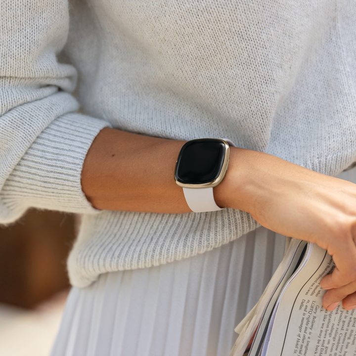 Close up shot of a woman wearing the Fitbit Sense on her wrist