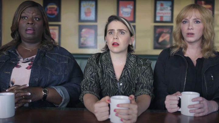 Three main female characters on Good Girls on Hulu sitting down with coffee mugs, looking terrified.
