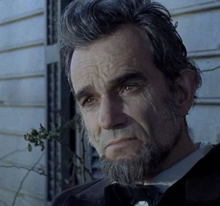 Daniel Day-Lewis as Abraham Lincoln sits down and stares in Lincoln.